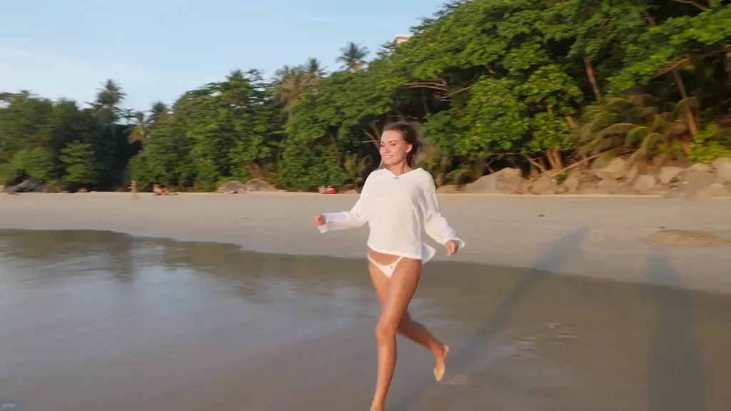 Stunning model Nicole Ross gets her thin white top wet at the beach