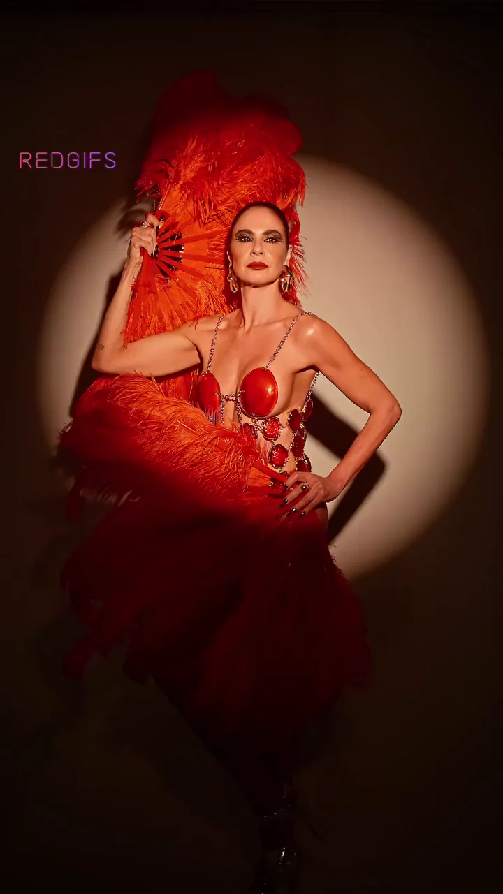 Luciana Gimenez Rocks Red Feather Tease with Killer MILF Curves