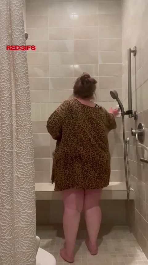 Cleaning the shower in an oversized tee