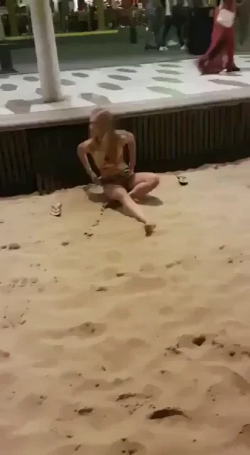 Jilling on the beach with people walking past