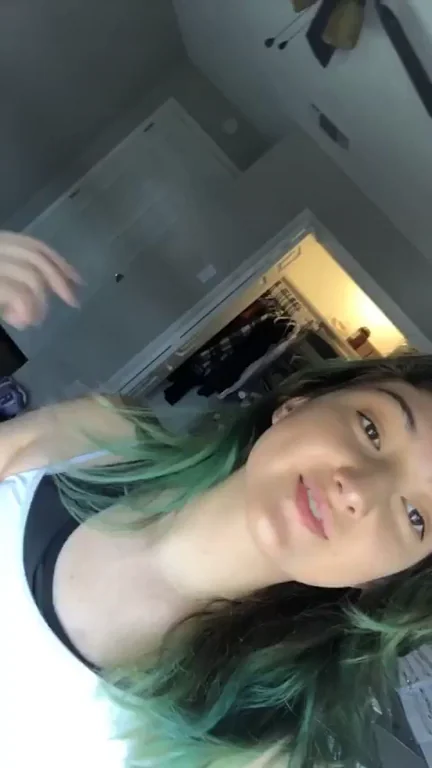 Chocolate Munchin' Tease: Green-Haired Slut Lifts Shirt for Perky Tit Flash
