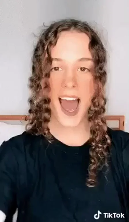 Naughty TikTok Tease: Curly-Haired Cutie's Wild Open-Mouth Shock